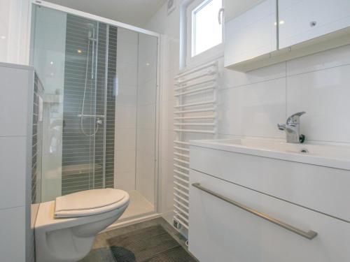 ein weißes Bad mit einem WC und einem Waschbecken in der Unterkunft Grote Karekiet 24-22 in Breukelen