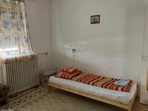 Cama en habitación con radiador en Dózsa apartman, en Hajdúszoboszló