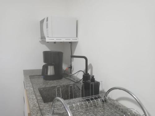 a kitchen counter with a sink and a microwave at Deslumbrante Apartamento Central in Curitiba