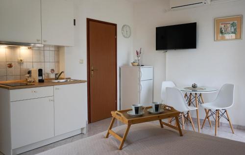 eine Küche mit einem Tisch und einem weißen Kühlschrank in der Unterkunft Apartments by the sea Sukosan, Zadar - 6229 in Sukošan