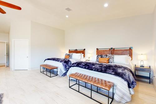 Un dormitorio con dos camas y un banco en él. en Casita de la Maracuyá & Tierra De La Maracuyá, en Fallbrook
