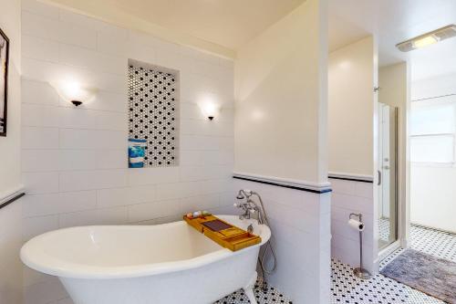 Un baño blanco con bañera y lavabo. en Casita de la Maracuyá & Tierra De La Maracuyá, en Fallbrook