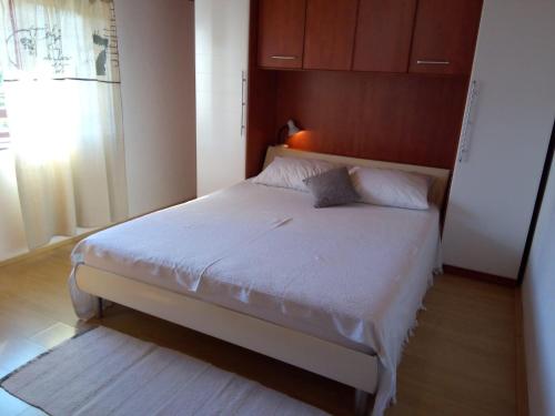 a bedroom with a white bed with a window at Apartment Kraj 8372b in Tkon