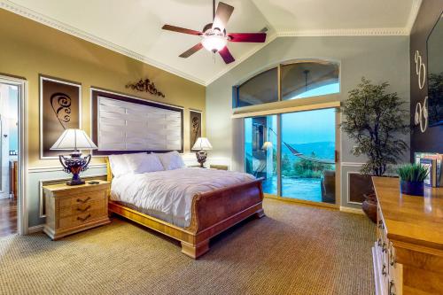 1 dormitorio con 1 cama, ventilador de techo y ventana en Luxury Mountain Getaway, en Ukiah