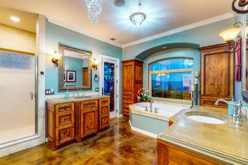 baño con 2 lavabos, bañera y ventana grande en Luxury Mountain Getaway, en Ukiah