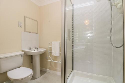 a bathroom with a shower and a toilet and a sink at Bramble Cottage in Falmouth