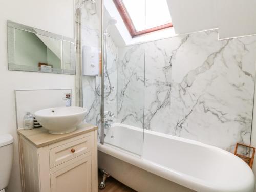 a white bathroom with a sink and a tub and a sink at Crinan Canal Cottage No8 in Lochgilphead