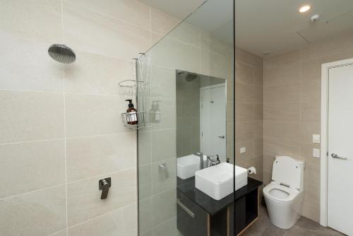 a bathroom with a toilet and a glass shower at Tekapo Lakefront Apartments in Lake Tekapo