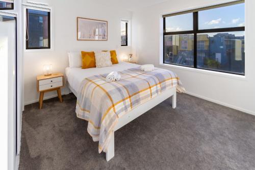 a white bedroom with a bed and a window at Large trendy 3 Bedroom Residence, Central City in Christchurch