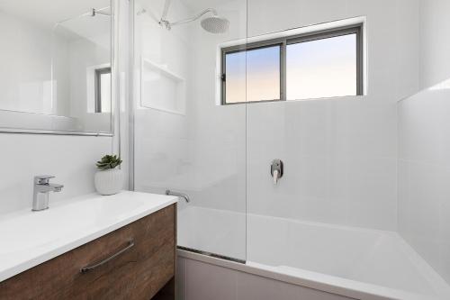 a white bathroom with a shower and a sink at Reflections Massy Greene - Holiday Park in Brunswick Heads