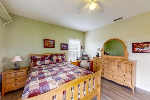Schlafzimmer mit einem Bett, einer Kommode und einem Spiegel in der Unterkunft Satterfield Boathouse in Donalsonville