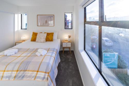 a bedroom with a bed and a large window at Large trendy 3 Bedroom Residence, Central City in Christchurch