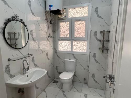 y baño con aseo, lavabo y espejo. en شقه عصريه, en Madinat Al Ashir min Ramadan