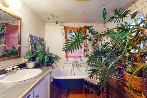 een badkamer met een wastafel en een bad met planten bij Katuah in Plainfield