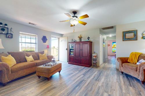 a living room with a couch and a ceiling fan at Fly Inn Cottage in Rhome