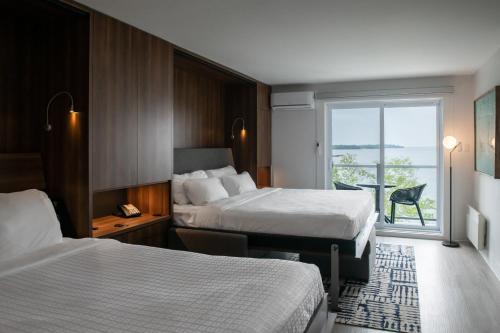 um quarto de hotel com duas camas e uma janela em Auberge Des Îles em Saint-Gédéon