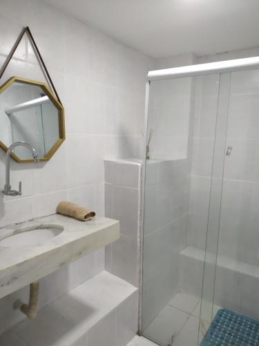 a white bathroom with a shower and a sink at No coração do Pelourinho, perto de tudo. in Salvador