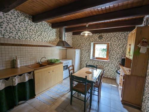 une cuisine avec une table, des chaises et un réfrigérateur dans l'établissement Maison de charme en pierres, proche de la nature, idéale pour balades, proche Épinal - FR-1-589-73, à Girancourt