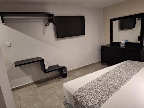 a hotel room with a bed and a television at Hotel Costa Verde in Veracruz