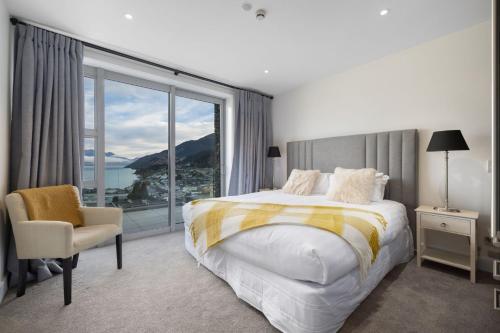 a bedroom with a bed and a large window at Catalina Apartment 5 in Queenstown