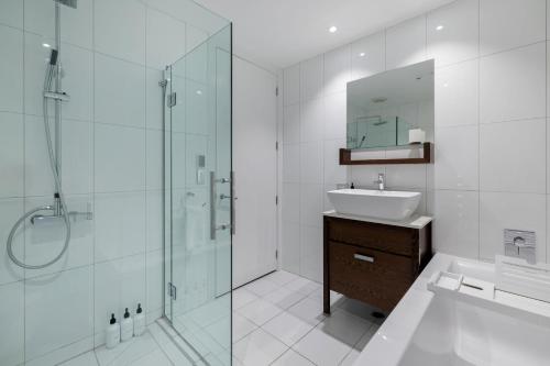 a white bathroom with a sink and a shower at Catalina Apartment 5 in Queenstown