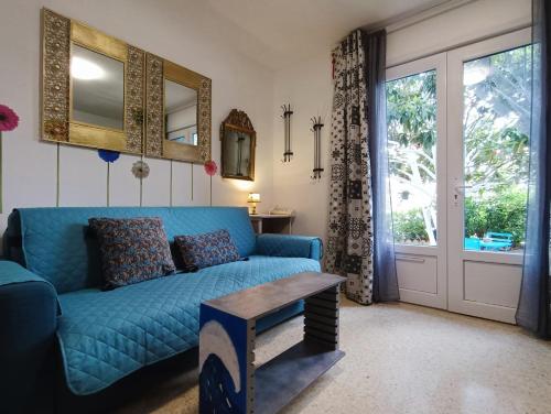un soggiorno con divano blu e finestra di L'oasis paisible a Castelnau-le-Lez
