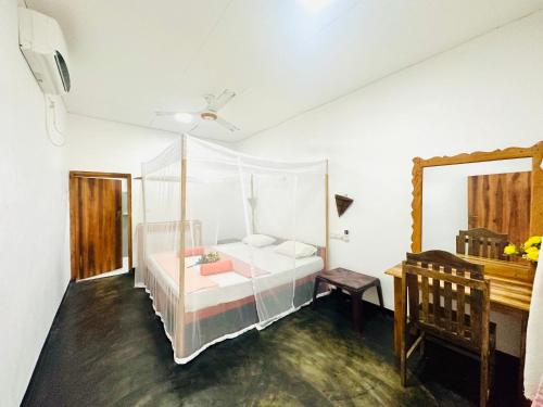 1 dormitorio con cama, espejo y piano en Beach Wave Hotel, en Arugam Bay