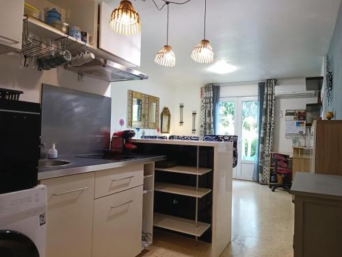 een keuken met witte kasten en een zwart aanrecht bij L'oasis paisible in Castelnau-le-Lez