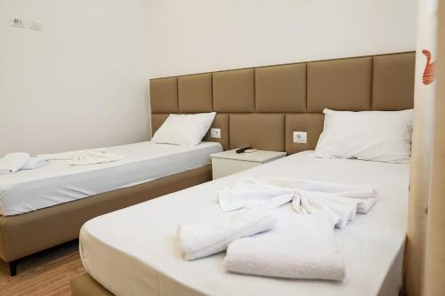 duas camas em um quarto com toalhas em Mega Hotel em Gjirokastër