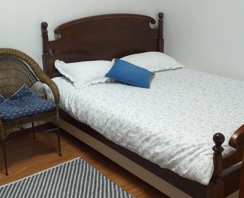 1 cama con almohada azul y silla en SoGoBe Pension, en Jeju