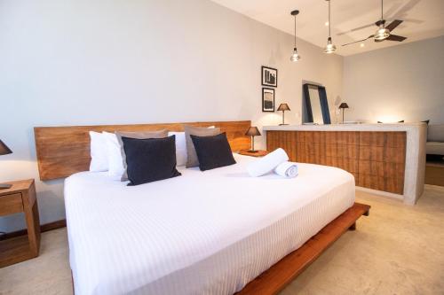 um quarto com uma grande cama branca num quarto em Unaluna by Rotamundos em Tulum