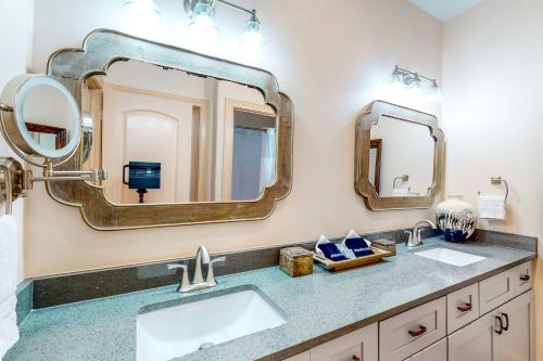 La salle de bains est pourvue de 2 lavabos et de 2 miroirs. dans l'établissement Patio Retreat, à The Woodlands