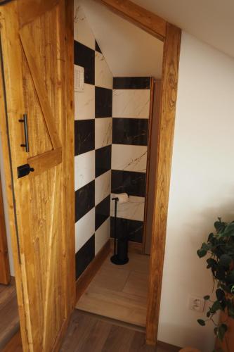 een badkamer met een zwart-witte geruite muur bij Apartmán U Borovice in Bílá Třemešná