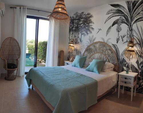 a bedroom with a large bed with blue pillows at Palm House Alvor in Alvor