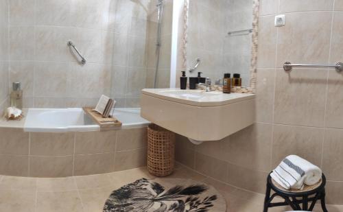 een badkamer met een wastafel en een bad bij Palm House Alvor in Alvor
