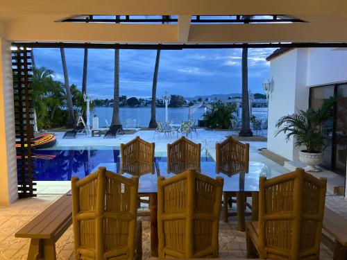 een patio met een tafel en stoelen en een zwembad bij El Peñón, Girardot-Colombia in Girardot