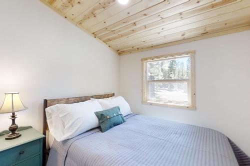 a small bedroom with a bed and a window at Little Pine Cabin at Big Pine Retreat in Crescent