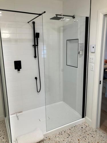 La salle de bains est pourvue d'une douche avec une porte en verre. dans l'établissement Yin et Yang, à Sainte-Anne-de-Beaupré