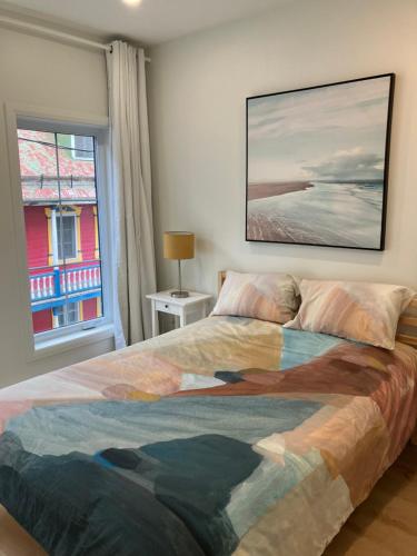 a bedroom with a large bed and a window at Yin et Yang in Sainte-Anne-de-Beaupré