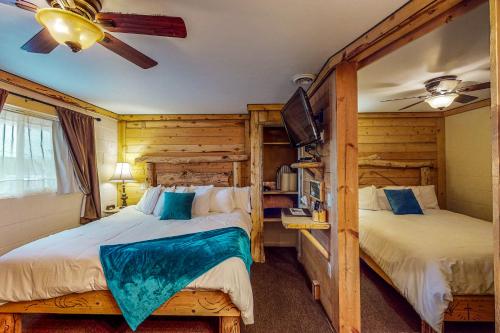 um quarto com 2 camas e uma ventoinha de tecto em Cedaredge Lodge, Cabin 5 em Cedaredge