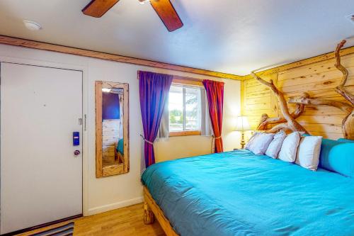 Un dormitorio con una cama azul con una rama de árbol. en Cedaredge Lodge Cabin 4 en Cedaredge