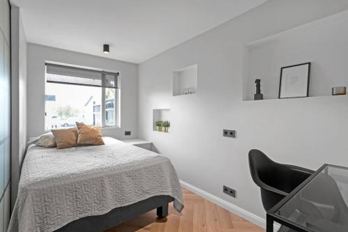a bedroom with a bed and a black chair at A modern and stylish furnished house in Reykjavík in Reykjavík
