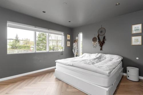 a bedroom with a white bed and a window at A modern and stylish furnished house in Reykjavík in Reykjavík