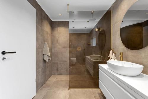 a bathroom with a white sink and a tub at A modern and stylish furnished house in Reykjavík in Reykjavík