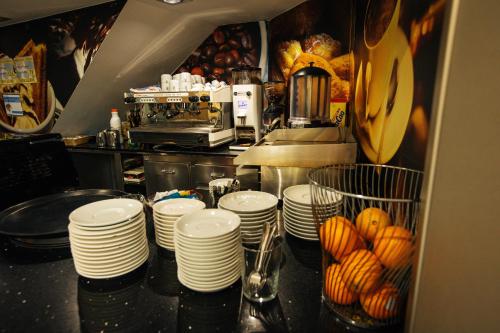 a kitchen with a counter with stacks of plates at Hotel Montedobra in Torrelavega