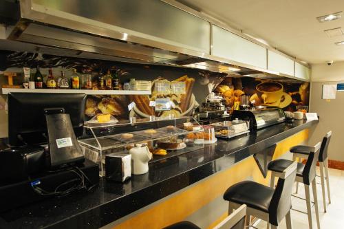 a restaurant kitchen with a counter with food at Hotel Montedobra in Torrelavega