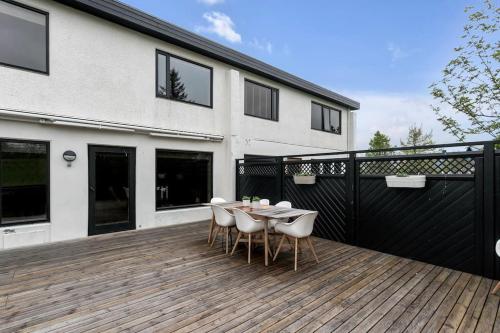 a wooden deck with a table and chairs on a house at A modern and stylish furnished house in Reykjavík in Reykjavík
