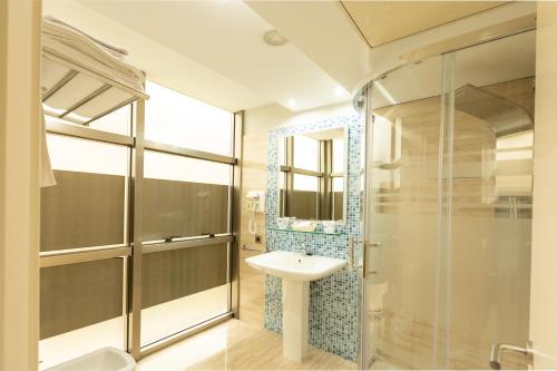 a bathroom with a sink and a glass shower at Hotel Montedobra in Torrelavega