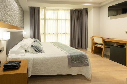 a hotel room with a bed and a desk at Hotel Montedobra in Torrelavega