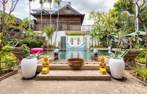 a swimming pool with a fountain in a garden at Green BOUTiQUE in Siem Reap